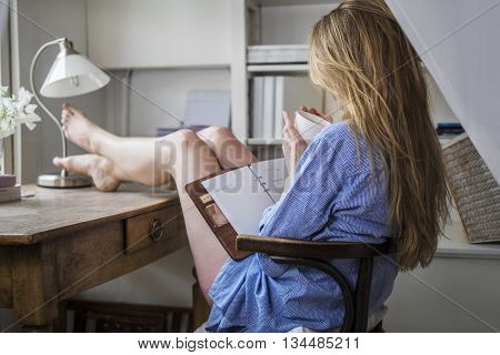 Attractive blonde drinking morning coffee in her home office