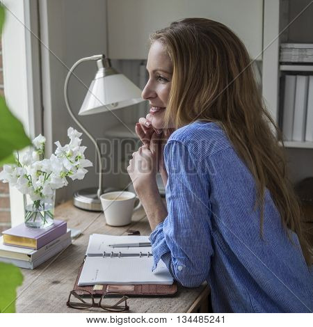 Attractive woman sitting in her home office in the morning