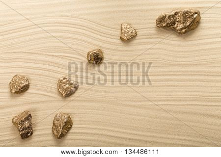 Golden stones in form of constellation Ursa Minor on waved sand. Photo can be used as a whole background.