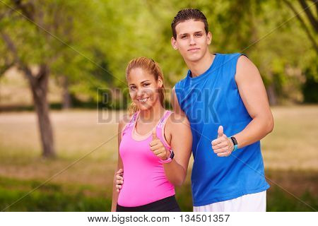 Young people doing sport activities girl and friend running man and woman using fitness watch. 