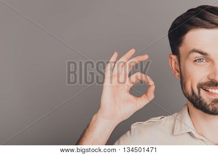 Half-face Portrait Of Cheerful Man Showing Ok Gesture