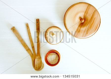 Kitchen wooden utensils on a white table. View from above with copy space.