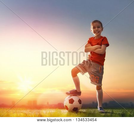 Cute little child dreams of becoming a soccer player. Child plays football.