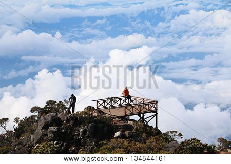 MOUNT KINABALU, SABAH BORNEO MALAYSIA - JUNE 12, 2016: Unidentified hikers having rest and enjoying the view of Ranau at the balcony of Mount Kinabalu new route trail.