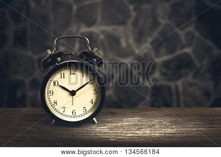 Alarm Clock On Wood With Blurry Stone Walls In Background