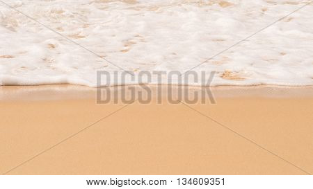 Beach. Soft white wave foam of the sea on sandy beach at Phuket Thailand. Summer time at sea beach concept. Copy space for some text.
