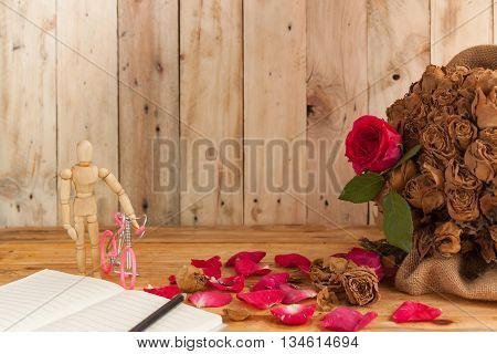The concept the love red roses romantic other forever.? Model tiny dummy bicycle on wood background.