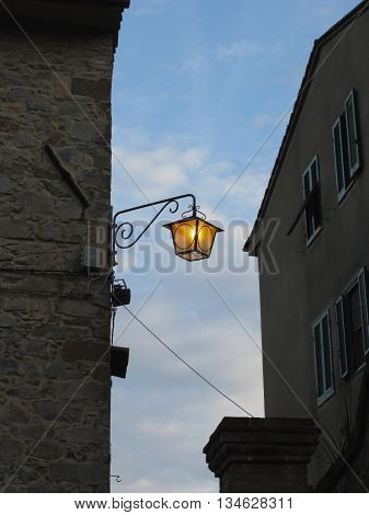Vintage street lamp in medieval village at twilight. Tuscany Italy