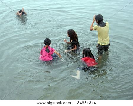 CEBU CITY, CEBU / PHILIPPINES - JULY 30, 2011: Children play in the water at a public beach in Cebu.