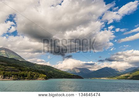Blue Lake Amid Mountain Range And Dramatic Sky In Idyllic Uncontaminated Environment Once Covered By