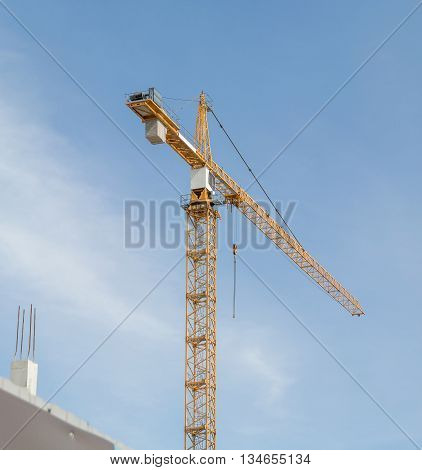 Huge crane and construction plant. Big construction crane and the building against the sky background. Tower Crane in Construction site.