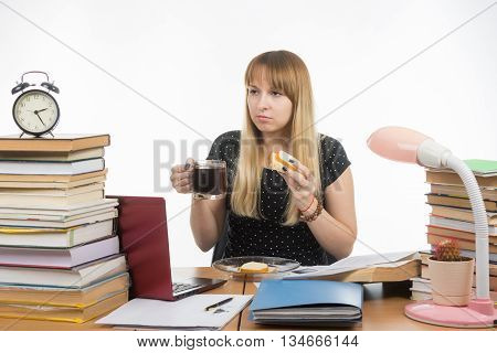 Hungry Young Teacher Sitting Wearily With A Sandwich And Coffee