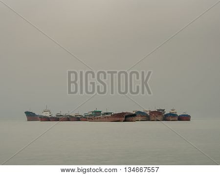 Rusty ships on the ocean waiting to dock