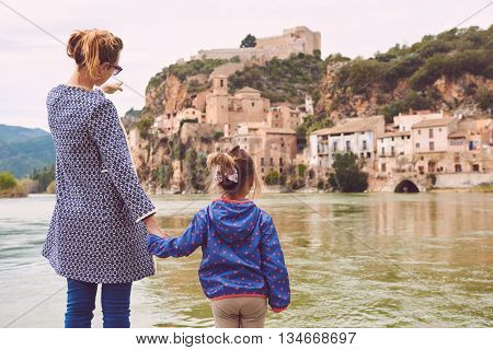 Mother and daughter travellers enjoying view of the Miravet village and Ebro river. Province of Tarragona. Spain