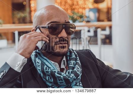 Arab businessman talking on mobile phone at a shopping center