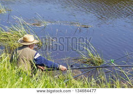 The river Kargat Novosibirsk oblast Siberia Russia - June 12 2016: a fisherman catches a fish on the river on a float
