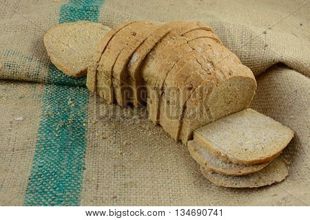 Frozen thawing loaf of sliced bread on burlap