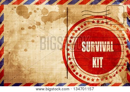 Survival kit sign, red grunge stamp on an airmail background