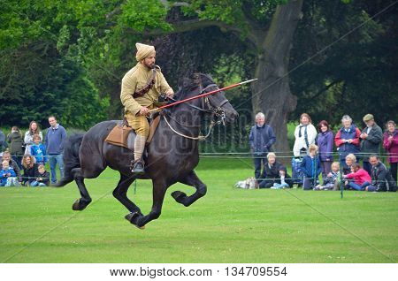 Silsoe, Bedfordshire, England - May 30, 2016: Demonstration of the sport of Tent Pegging at full gallop  by a member of the Punjab Lancers in World War One uniform