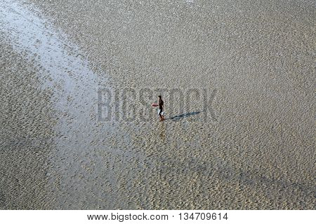 CANNING TOWN, WEST BENGAL, INDIA - FEBRUARY 13: During low tide the water in the river Malta falls so low that people walk to the other shore in Canning Town, India on February 13, 2014.
