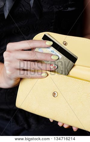 Woman hand putting a credig card into her wallet