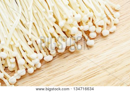 The fresh Enoki mushrooms on wooden table.