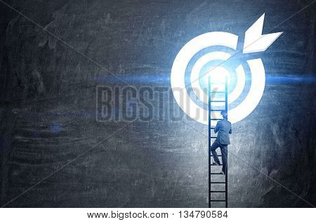 Targeting concept with businessman climbing ladder to abstract illuminated dartboard sketch on chalkboard
