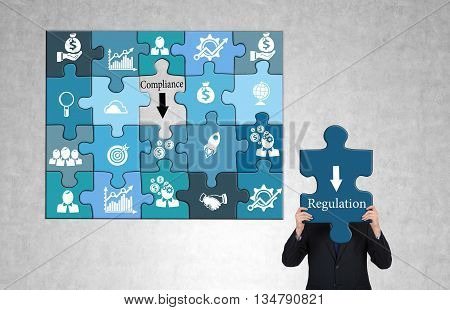 Regulation and compliance concept with business icon puzzles and businessman on concrete background