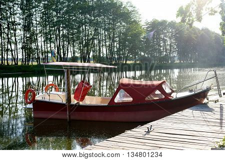 a cutter stands at a pier at the river near a bridge