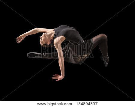 Young woman ballerina stretching warming up in silhouette studio on black background