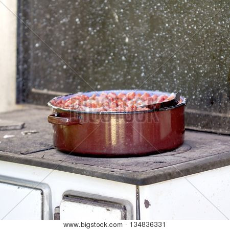 Cooking strawberry jam on an big suace pan
