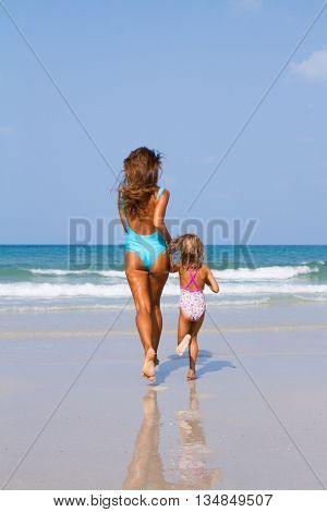 Mum with daughter on the beach in Thailand