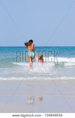 Mum with daughter on the beach in Thailand