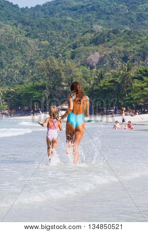 Mum with daughter on the beach in Thailand