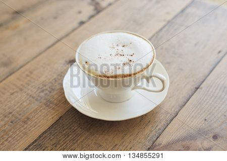 Beautiful hot cappuccino on wooden table background