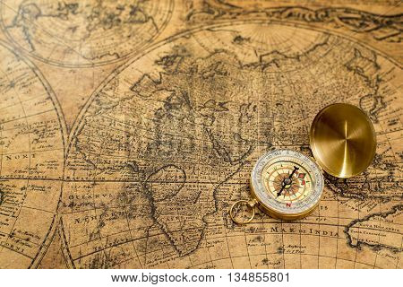Beautiful old compass on vintage map bcakground