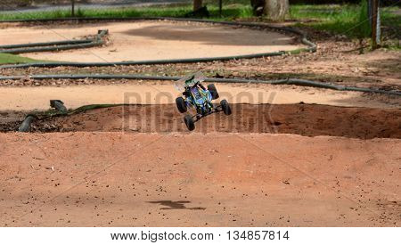 Sydney, Australia - December 14, 2014. Radio controlled buggy car model in race, internal combustion engine on a bumpy red clay road. (St Ives Showground, Sydney, Australia)