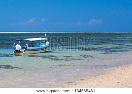 A Balinese fishing boat moored on a Sanur beach in Bali, Indonesia