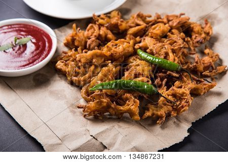 Crispy onion bhaji or kanda bhaji or fried onion pakore or pakode, delicious street food, favourite indian snack in monsoon served with hot tea