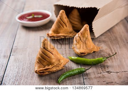 Samosa snack with tomato ketchup and hot tea, Fresh samosas with ketchup and hot chai ready for breakfast