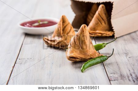 Samosa snack with tomato ketchup and hot tea, Fresh samosas with ketchup and hot chai ready for breakfast
