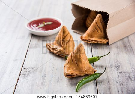 Samosa snack with tomato ketchup and hot tea, Fresh samosas with ketchup and hot chai ready for breakfast
