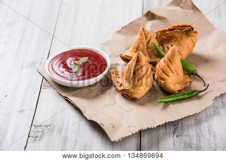 Samosa snack with tomato ketchup and hot tea, Fresh samosas with ketchup and hot chai ready for breakfast