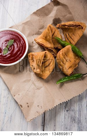 Samosa snack with tomato ketchup and hot tea, Fresh samosas with ketchup and hot chai ready for breakfast