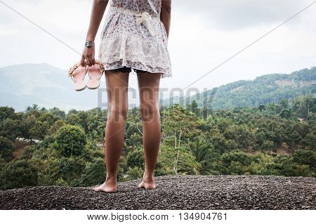 Beautiful women standing on the stone at mountain sunset background