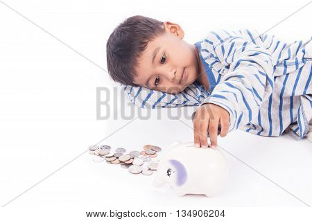 cute asian boy saving money in piggy bank