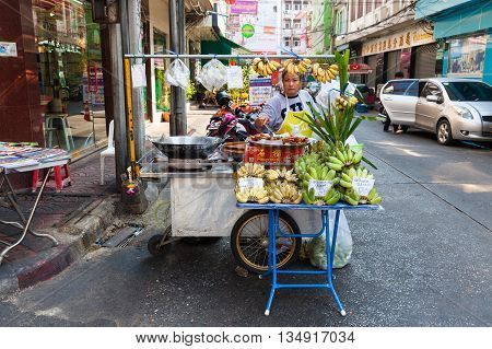 BANGKOK THAILAND - APRIL 24: Woman selling fruits on the street of Bangkok Chinatown on April 24 2016 in Bangkok Thailand.