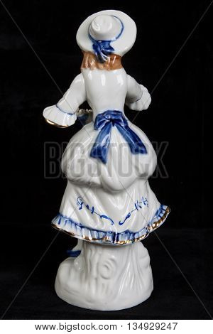 porcelain figurine in the form of a girl in medieval dress isolated on a black background