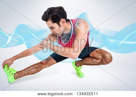 Male athlete stretching his hamstring against grey background