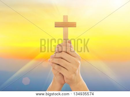 Human hands holding a cross holy and prayed for blessings from God. Amour Worship God concept.